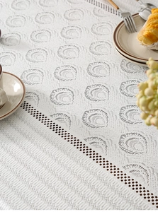 Detail of white ivory tablecloth with embossed vortex texture and hollow mesh lace edges