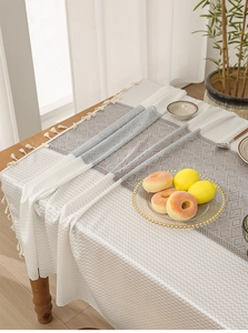 Close-up of French jacquard lace tablecloth with hollow geometric patterns and tassels