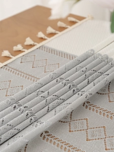Macro detail of light blue geometric hollow lace tablecloth with delicate fringe edge
