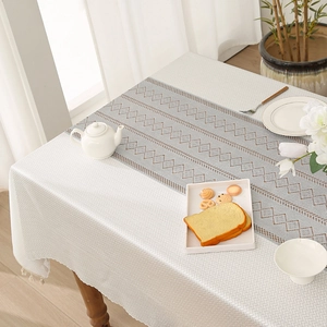 Beige jacquard tablecloth with tassel fringe and geometric table runner for dining room