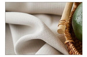 Macro detail of natural beige linen tablecloth texture with soft folds and rustic basket
