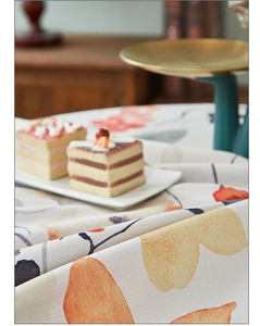 Detailed texture of thick linen tablecloth with orange floral pattern in a tea setting