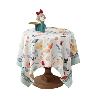 Watercolor floral round tablecloth in thick cotton linen on a wooden table