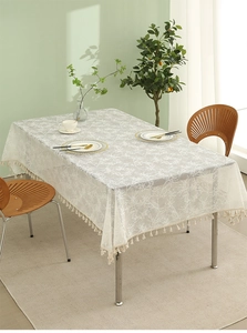 Detail of white rectangle lace tablecloth with branch patterns and tassel fringe trim