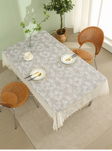 Detail of white rectangle tablecloth with branch pattern and lace fringe tassels