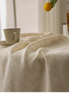 Close-up of thick beige linen tablecloth featuring a textured square weave pattern