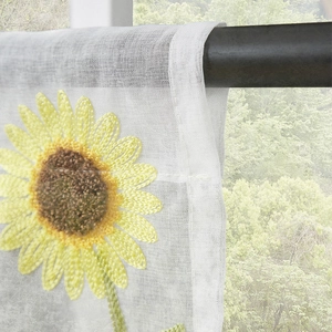 Close-up of sunflower embroidery on white semi-sheer mesh curtain hanging on a rod