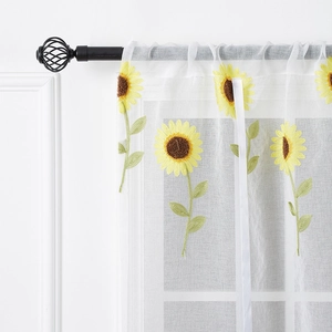 White sheer curtain with embroidered yellow sunflowers on a black decorative metal rod