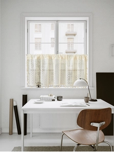 Detail of cream lace cafe curtain with intricate hollow weaving and elegant fringe trim