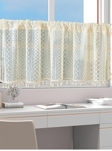 Detail of crochet lace cafe curtain with geometric wave patterns and fringe tassels