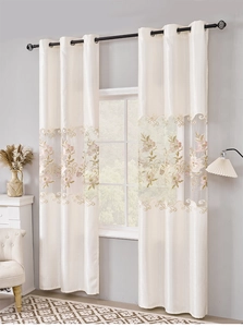 Detail of European embroidered floral sheer curtain and cream blackout panel with metal rings