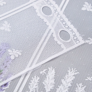 Close-up of white floral lace curtain detail with delicate embroidery and rod pocket