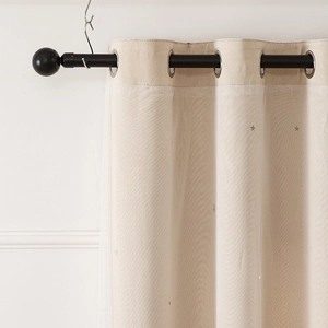 Close-up of beige double-layer curtains with sheer fabric and silver hollow star patterns
