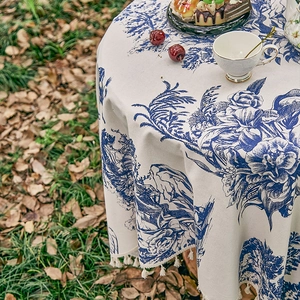 Detail of French vintage blue floral tablecloth with elegant beige fringe tassels