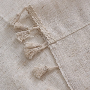 Dettaglio del tessuto per tende effetto lino con bordo all'uncinetto e nappe eleganti