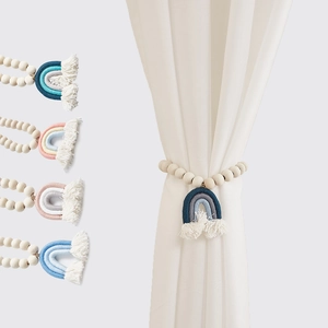Dettaglio di fermatende boho con nappe arcobaleno fatte a mano e perline di legno