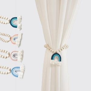 Dettaglio di fermatende arcobaleno fatti a mano con perle in legno e nappe in cotone