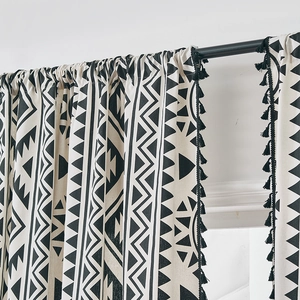 Detail of bohemian geometric print curtain with black tassels and linen texture