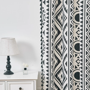 Detail of bohemian black and white geometric pattern curtain with textured fabric and tassels