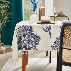 Nappe style campagne française à fleurs bleues avec des pompons beige sur table