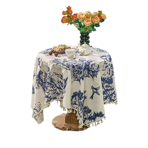 Blue vintage floral print tablecloth with tassels on a small table for tea time