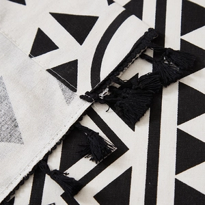 Detailed close-up of Bohemian black and white geometric print linen curtain with tassels