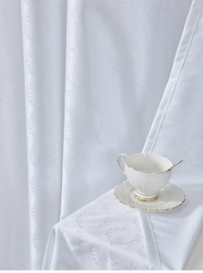 Detail of white jacquard outdoor curtain fabric featuring elegant leaf ring patterns
