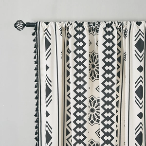Detail of bohemian geometric black and white cotton linen curtain with black tassel fringe