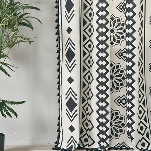Detailed view of bohemian black and white geometric print curtain with cotton tassel fringe