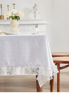 Detailopname van elegant wit jacquard tafelkleed met verfijnde kanten randafwerking
