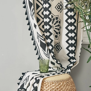 Detail of bohemian cotton linen curtain with black geometric prints and tassel edges