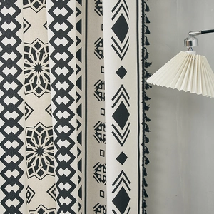 Detail of bohemian black and white geometric pattern curtain with black fringe tassels