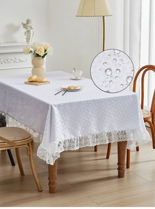 Detail van waterdicht wit kant tafelkleed met geometrisch patroon en waterdruppels