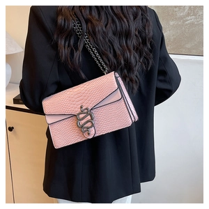 Detail der rosa Handtasche mit Schlangenhaut-Prägung, Schlangenkopf-Verschluss und Kette