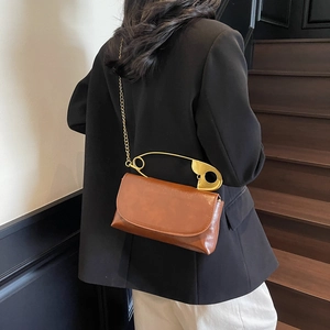 Brown retro crossbody bag with large gold safety pin handle and chain strap