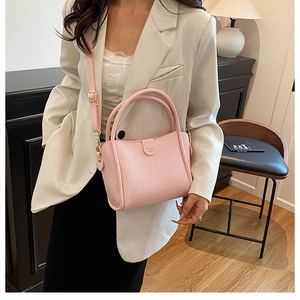 Pink lychee texture bucket bag with shoulder strap styled with a white blazer