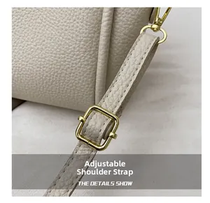 Detail of adjustable strap with gold buckle on beige lychee leather bucket bag