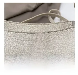Detail showing beige lychee grain leather and WANMEI & BAG FASHION embossed flap