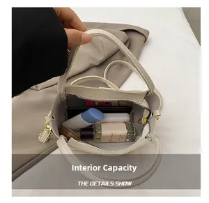 Macro shot of the spacious interior of the beige leather bucket bag with daily items