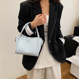 Light blue lychee pattern leather bucket bag with top handle for women in a minimalist setting