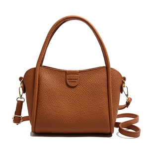 Brown lychee leather bucket bag with dual handles and detachable shoulder strap