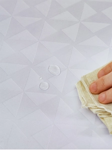 Detail van waterdicht tafelkleed met 3D-geometrische textuur en glanzende waterdruppels