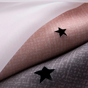 Detail of laser-cut star patterns on multi-layer gradient rainbow blackout curtains
