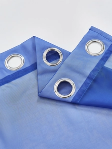 Detail of blue semi-transparent sheer curtain with silver metal grommets for easy hanging
