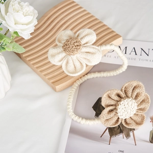 Floral curtain tiebacks with linen flowers and thick braided rope in rustic home style