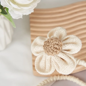 Floral curtain tieback with white rustic petals and brown braided center on rope