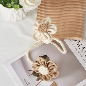 Detail of hand-woven floral curtain tieback with cream and brown cotton flower design