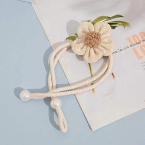 Detail of creative floral curtain tieback with woven fabric flower and pearl accents