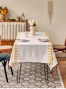 French vintage beige tablecloth with yellow star embroidery in a cozy dining room