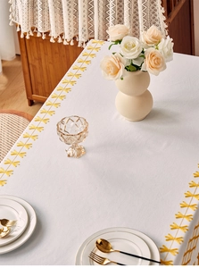 Detail of yellow geometric embroidery on cream linen-cotton waterproof tablecloth
